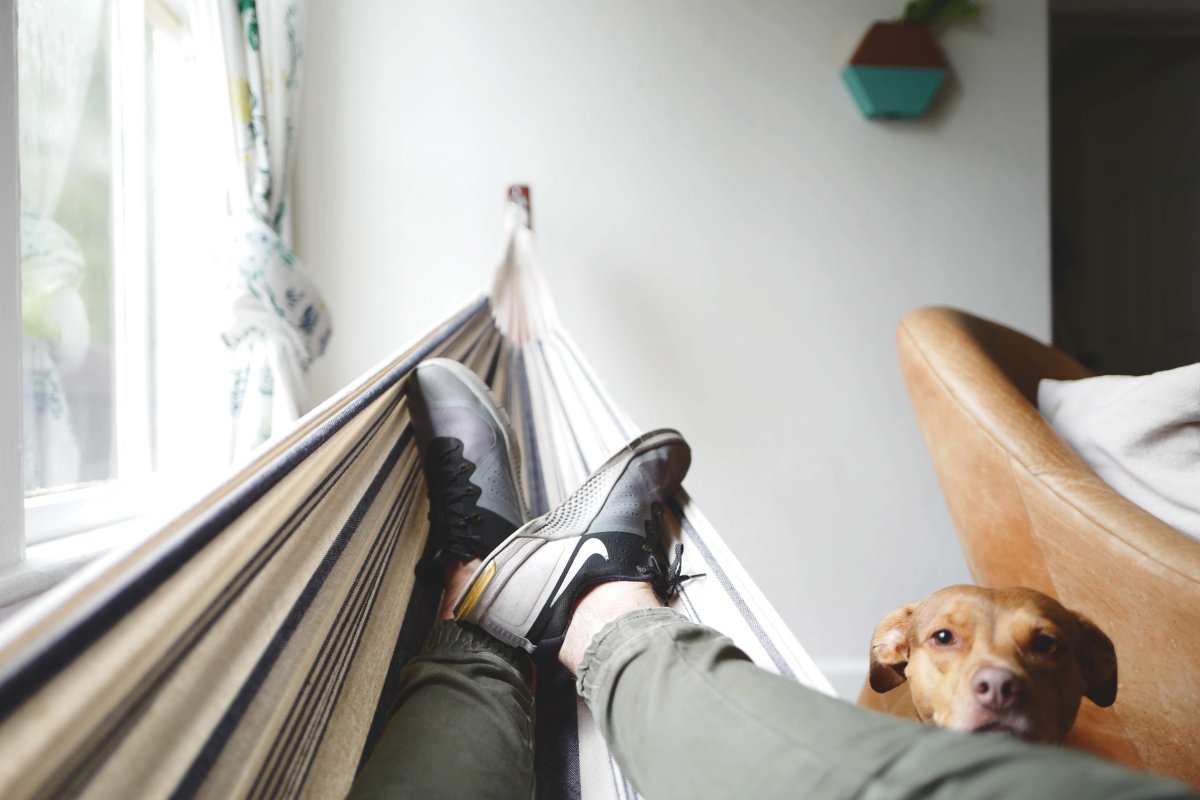 A person relaxing in hamock in their house. 