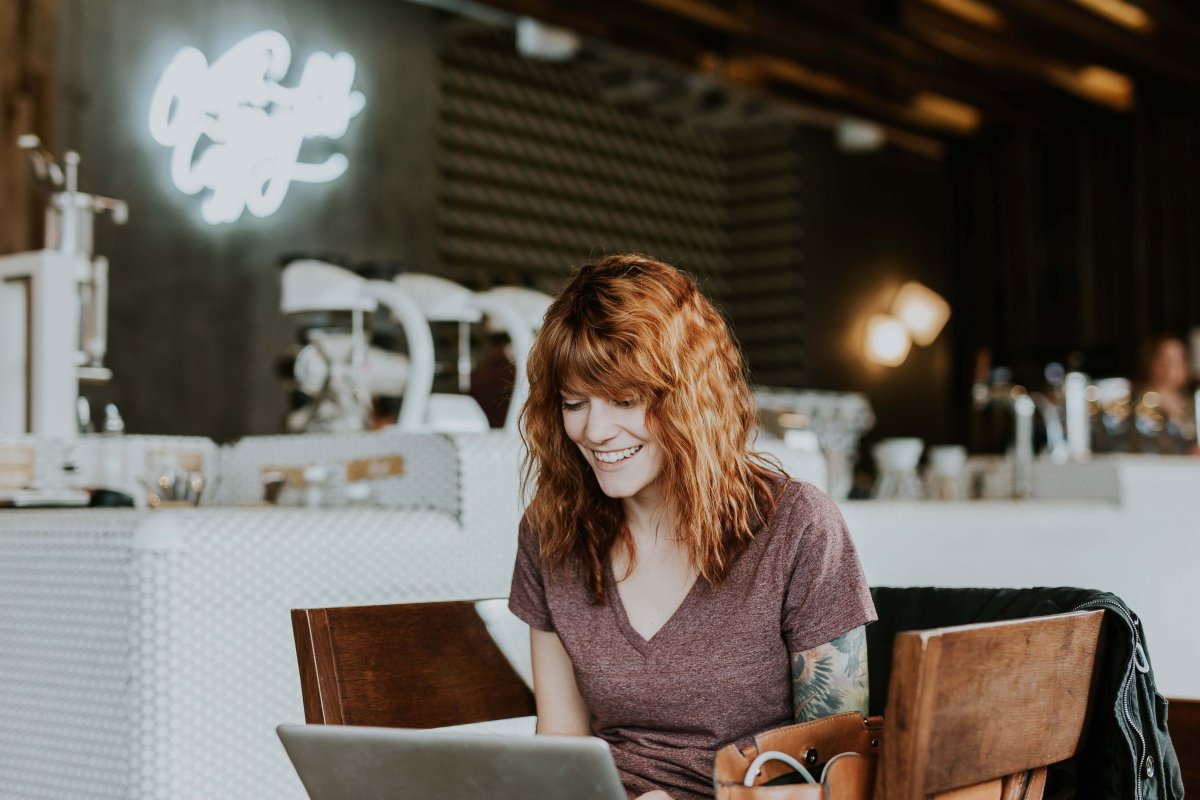 Photo of a lady at her laptop looking happy.